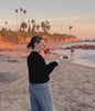 Drinking a NOORA Calm pouch on the beach at sunset